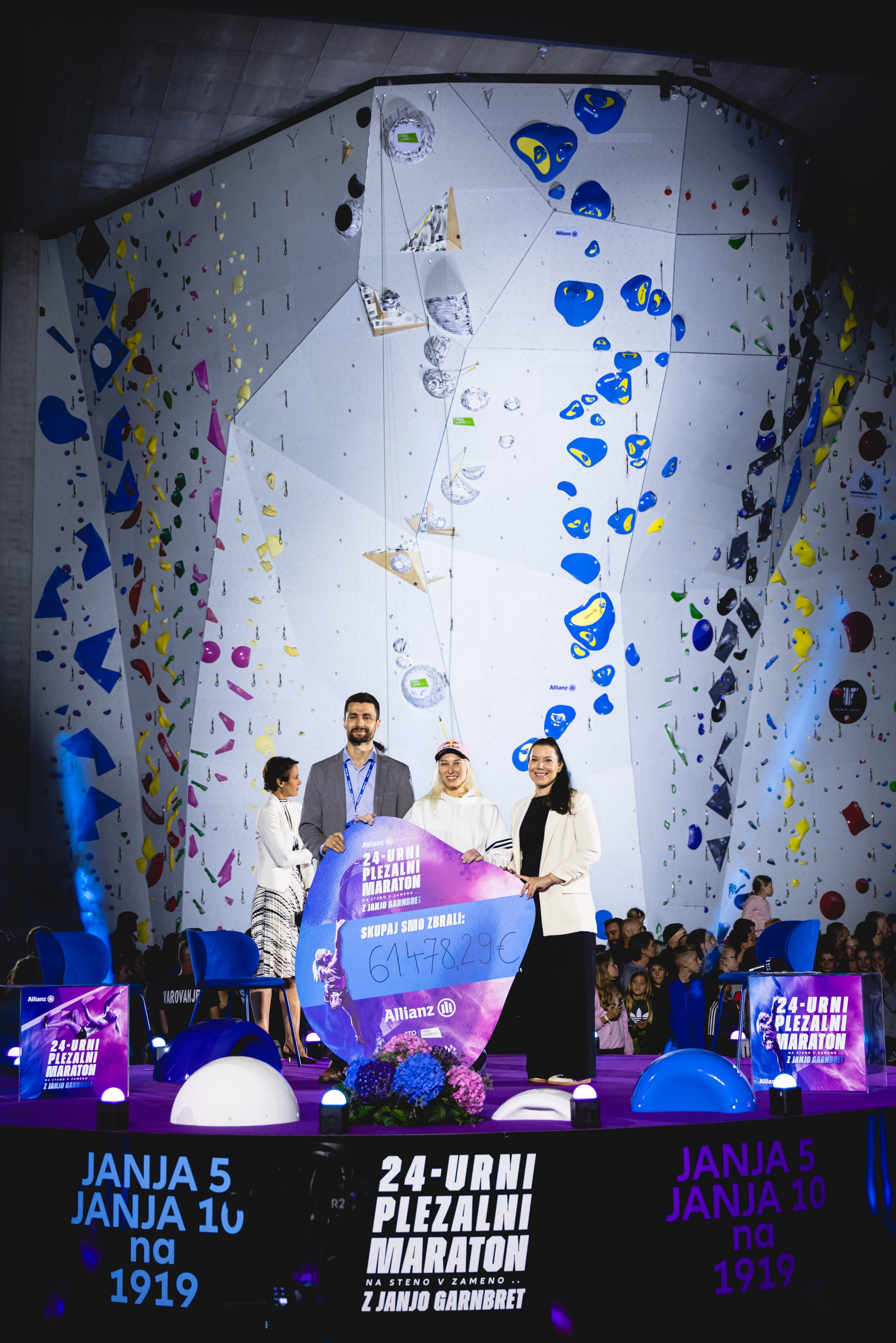 David Živković, direktor Allianz Slovenija, podružnice, in Janja Garnbret izročata ček 61.478,29 EUR predstavnici Botrstva v športu Doris Rojo